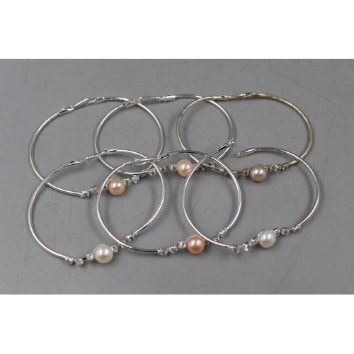 130 - A Selection of Six Pearl and Clear Stoned Designer Bracelets.