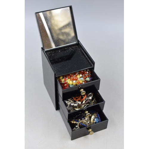 131 - A Three Drawer Black Floral Jewellery Box With a Selection of Unsorted Jewellery.