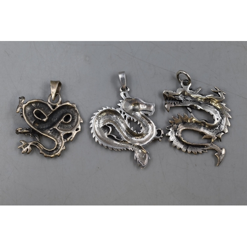 135 - Three Sterling Silver Chinese Dragon Pendants.