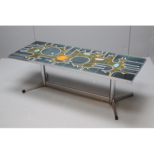 569 - A 1960s/70s polished metal coffee table, the rectangular top inset with a psychedelic abstract in co... 