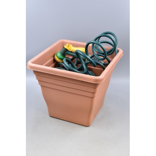 704 - Spiral Extending Water Hose and a Platic Planter