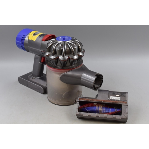 743 - A Handheld Dyson Vacuum Cleaner, With Charger. Powers on When Tested