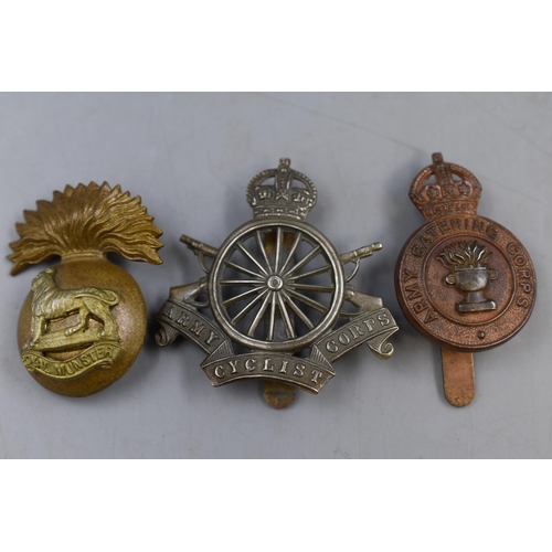 281 - Three Military Cap Badges to include Army Cycling Corps, Royal Munster and Catering Corps