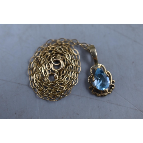 12 - An Unmarked Gold Blue Stoned Pendant, On 9ct Gold Chain