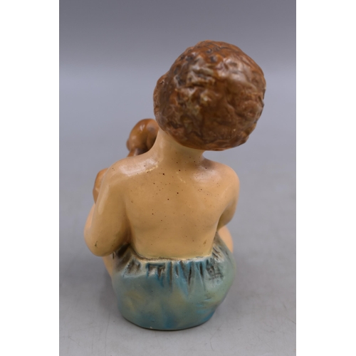 244 - An Antique Ceramic Baby Figure Holding Puppy, Marked 'Curls' To Base, Approx 6