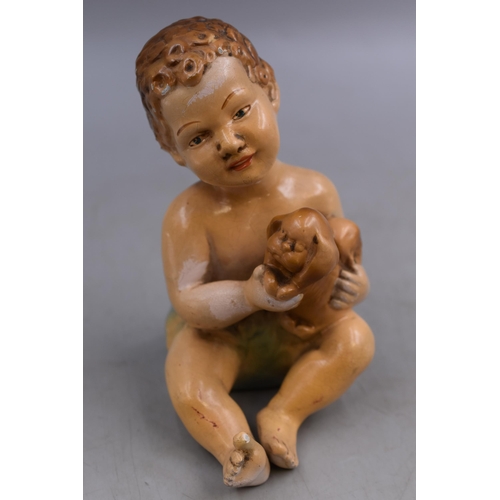 244 - An Antique Ceramic Baby Figure Holding Puppy, Marked 'Curls' To Base, Approx 6