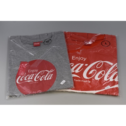 563 - Two Coca-Cola Official Merchandise T Shirts (Size M & L)