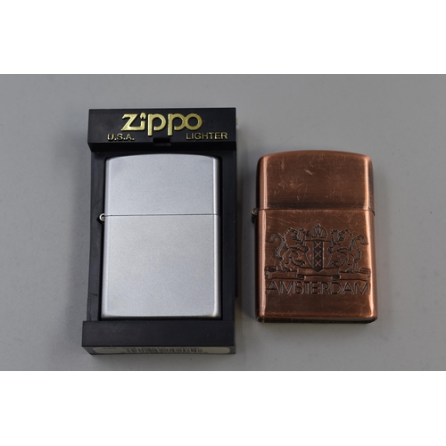 170 - Two Collectable Lighters To Include Copper Effect Amsterdam Lighter, And Silver Tone Zippo Lighter