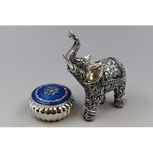 228 - Two Decorative itemes to include a Enamel Lidded Silver Effect Trinket Box and a Silver Effect Eleph... 