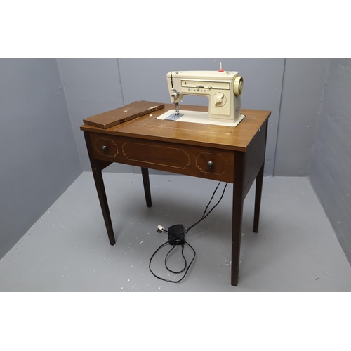 605 - A Retro Foldaway Singer Sewing Machine Table, Powers on When Tested. Some Cosmetic Damage to Wood Pa... 