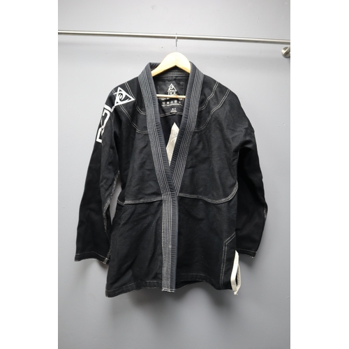 635 - A Two Piece Black Cotton Martial Arts Outifit, With White Belt. Belt Signed By Royce Gracie