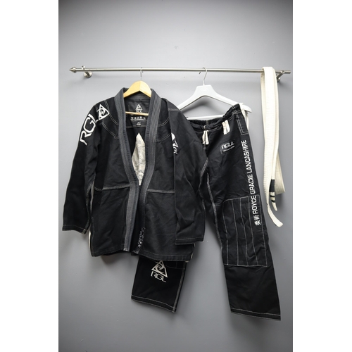 635 - A Two Piece Black Cotton Martial Arts Outifit, With White Belt. Belt Signed By Royce Gracie