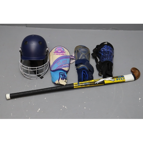 591 - A Selection of Sporting Items To Include Hockey Stick, Cricket Helmet, and Shin Pads