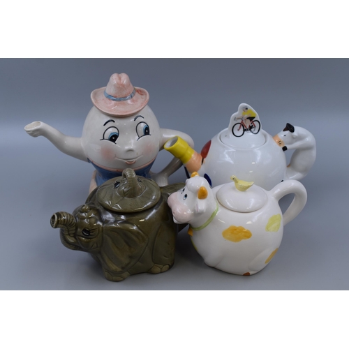 327 - Four Collectable Ceramic Teapots in the form of Humpty Dumpty, Elephant, Cow, and a Cravendale