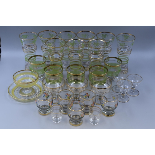 A Selection of Gold Rimmed Vintage Glassware. Includes Set of Nine Green Grape Glasses, Set of Five Floral Glasses, Yellow Hooped Dessert Dish on Plate, And More