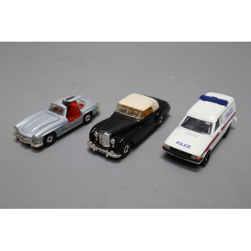 725 - A Selection of Unboxed Diecast Playworn Vehicles To Include Various Police Cars/Vans, Dinky Routemas... 