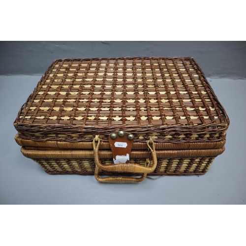 682 - Wicker four person picnic basket to include mugs, plates, bowls and cutlery.