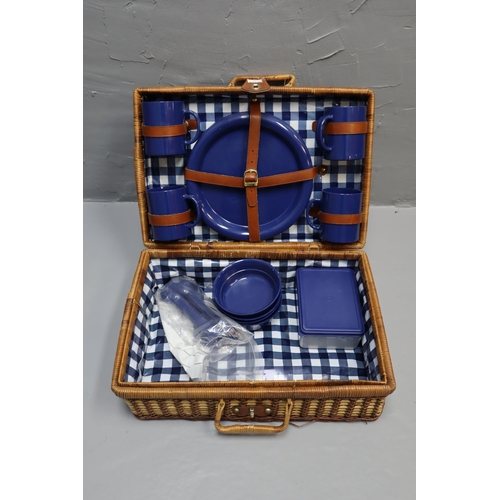 682 - Wicker four person picnic basket to include mugs, plates, bowls and cutlery.