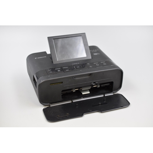 592 - Boxed Canon Selphy Compact Photo Printer CP1300 with spare ink and packs of papers inside powers on ... 