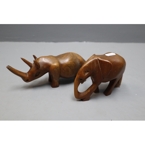 651 - Collection of hand carved wooded items to include, one hand carved Rino, one hand carved Elephant, o... 