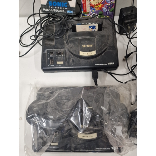 562 - Two Sega Megadrive Games Consoles. Power on but untested beyond that. Comes with 2 Games.