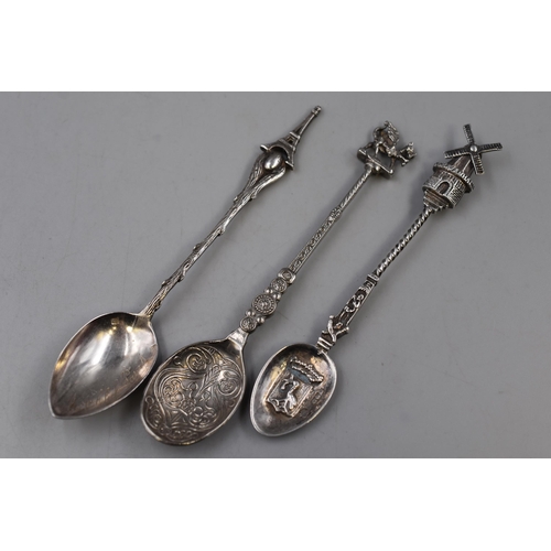 142 - Three Vintage spoons including A Dutch windmill themed spoon, A Paris Eiffel Tower themed spoon and ... 