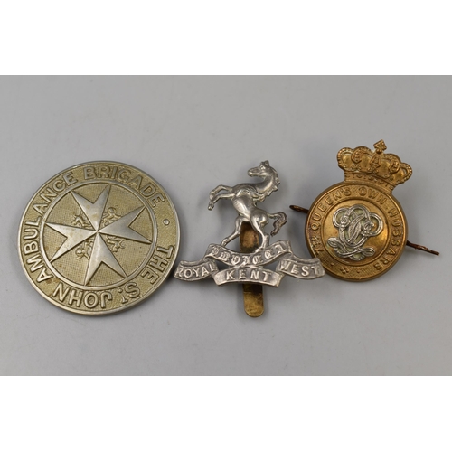 313 - Three Cap Badges To Include St John's Ambulance, Royal West Kent, And The 7th Queen's Own Hussars