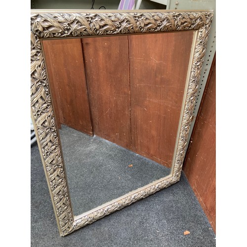 488 - Large beveled glass mirror in silver floral design embossed frame (47