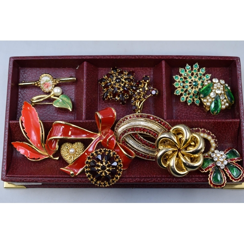 278 - A selection of brooches to include: to include big red bow brooch and more