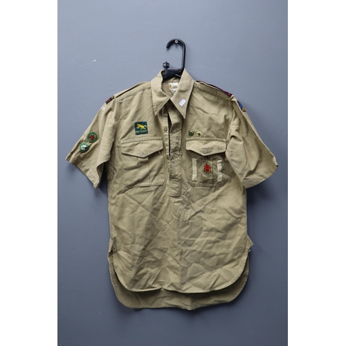 722 - Vintage boy scouts short sleeved shirt with a collection of badges sewed onto it