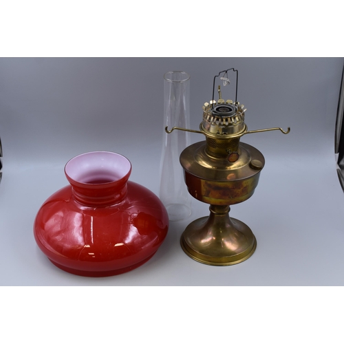 329 - An Aladdin 23 Vintage Brass Oil Lamp, With Red Glass Shade and Chimney. Approx 23.5