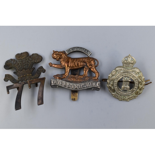 269 - Three Military Cap Badges including Isle Of White Rifles, Royal Leicestershire Regiment, and East Mi... 