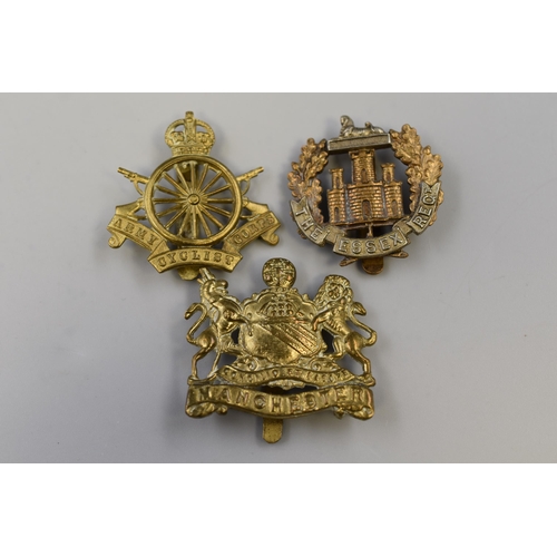 229 - Three Military Cap Badges To Include Manchester Regiment, Essex Regiment, And Army Cyclist Corps