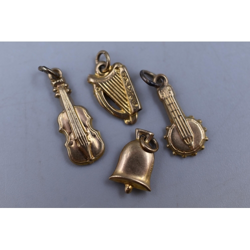 26 - A Selection of Gold 9ct Musical Charms to include a Harp, Guitar, Bell and Banjo