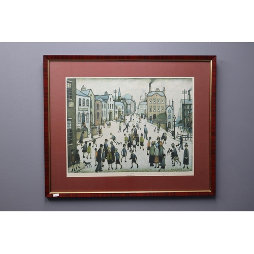 493 - A Framed and Glazed LS Lowry Print Titled 'A Village Square', Approx 27