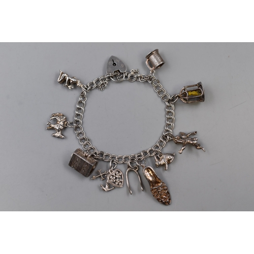 14 - A Sterling Silver Charm Bracelet With Nine (Some Unmarked) Charms, Approx 32.45g.