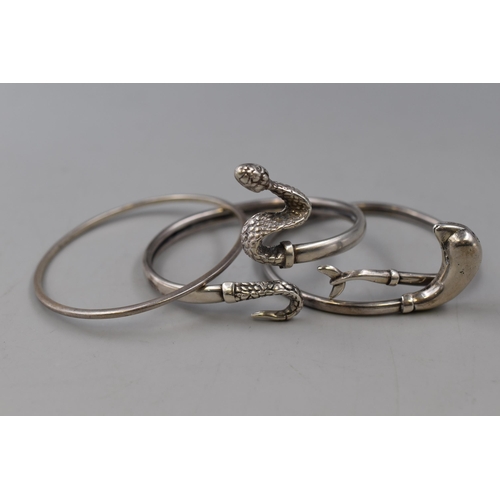 38 - Three Silver Bangles to include Dolphin and Snake Design