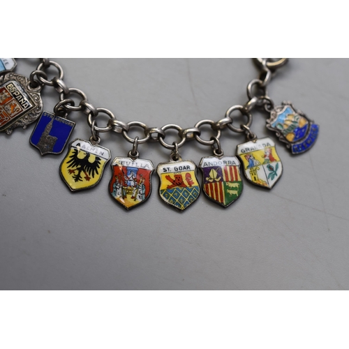 19 - A Silver Enamelled Souvenir Charm Bracelet With 24 Charms of Various Places. Approx 38 Grams