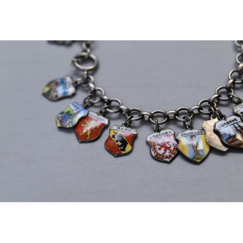 19 - A Silver Enamelled Souvenir Charm Bracelet With 24 Charms of Various Places. Approx 38 Grams