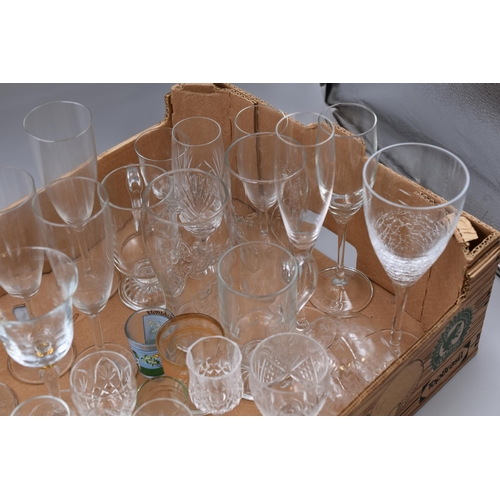 857 - Mixed lot of glassware includes wine glasses, pint glasses, shot glasses, champagne glasses and more