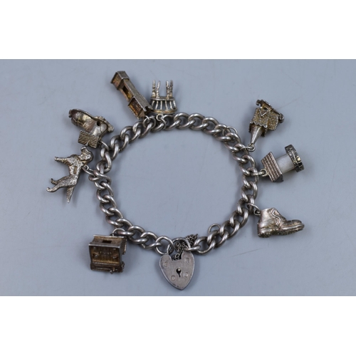 52 - A Hallmarked Birmingham Silver Charm Padlock Bracelet, With Eight Charms To Include Articulate (Appr... 