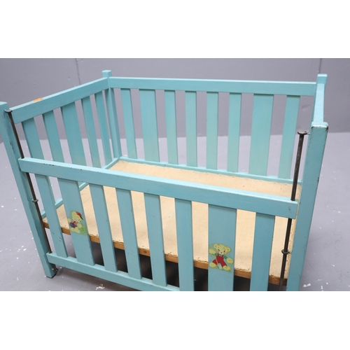 693 - A 1970's Doll's Cot, in Turquoise With Vintage Teddy Bear Transfers and Drop Down Side. Approx 47cm ... 