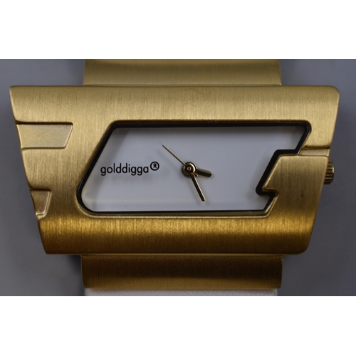 93 - A Ladies Goldigga Designer Watch, White Strap and Dial With Brushed Gold Tone Accents. In Presentati... 