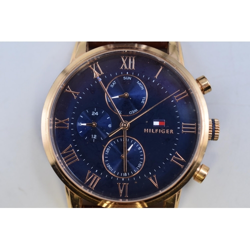 77 - A Tommy Hilfiger Blue Dial and Gold Tone Calendar Watch, With Leather Strap. Working