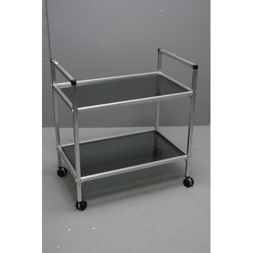 535 - A Brushed Metal and Smokey Glass Two Tier Modern Serving Trolley, On Castors. Approx 70cm Tall