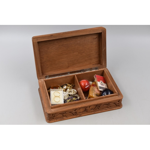 109 - A carved wooden jewellery box containing collectables and costume jewellery.