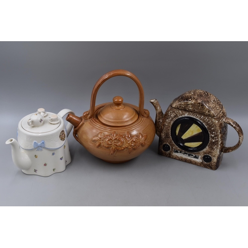 279 - Six novelty tea pots to include Fishermans friend, radio, Hovis, back pack, oriental and table