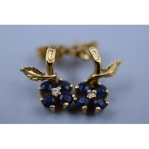 14 - A pair of 750 (18 Karat) gold earings with dark stones and central moissenite diamond