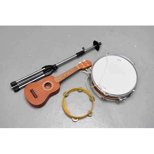 609 - A Selection of Instruments To Include Ukulele (With Chord Book), Tambourine, Trombone Stand, And New... 