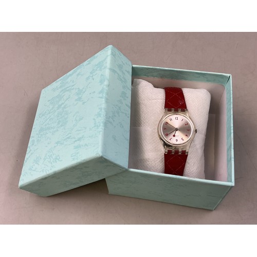 104 - A Ladies Swiss Swatch Quartz Watch, In Presentation Box - Brushed Metal Dial, Transparent Case, And ... 
